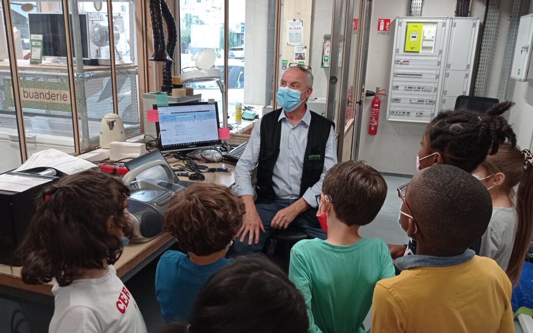 Photo illustrant un groupe d'enfants en train de découvrir l'atelier de réparation d'Envie Le Labo