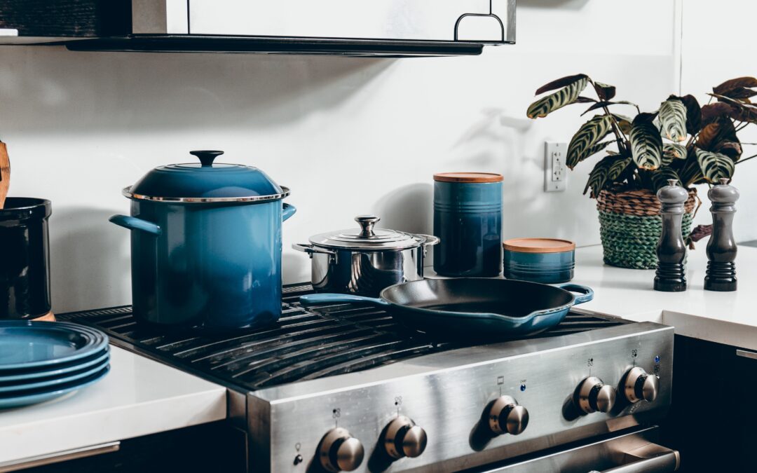 Photo d'une cuisinière argentée dans une cuisine moderne avec des ustensiles de cuisine bleus